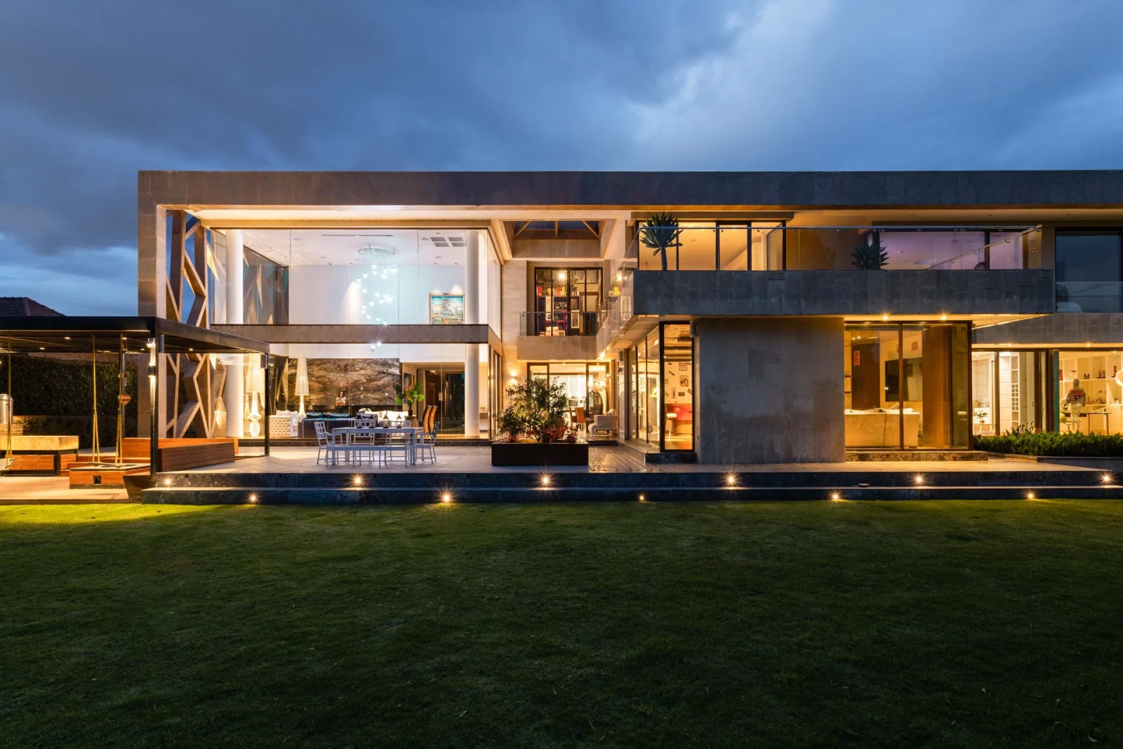 Modern home with architectural eave and accent lighting glowing at twilight